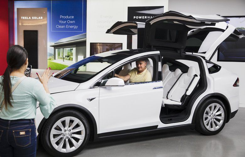 FILE — Visitors in a Model X at the Tesla storefront in the Aventura Mall in Aventura, Fla., Jan. 10, 2020. News about its battery suppliers and optimistic analyses helped lift the electric-vehicle maker’s share price on Feb. 3. (Scott McIntyre/The New York Times)  XNYT201 XNYT201