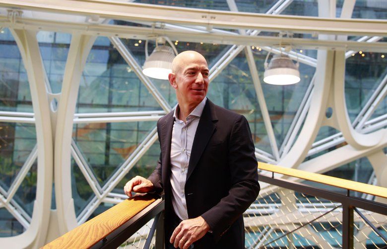 Jeff Bezos, center, tours The Spheres at Amazon’?s campus in downtown Seattle Monday, Jan. 29, 2018. The Spheres house more than 40,000 plants, and features waterfalls, fish tanks and 40-foot trees. 
 204988 204988

decade 13 influential