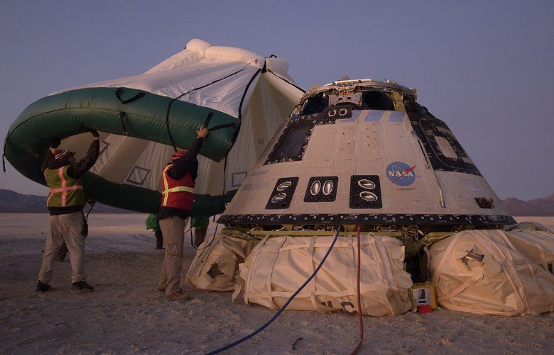 FILE – In this Sunday, Dec. 22, 2019 photo made available by NASA, Boeing, NASA, and U.S. Army personnel work around the Boeing Starliner spacecraft shortly after it landed in White Sands, N.M. On Friday, Feb. 7, 2020, NASA said defective software could have doomed the crew capsule during its first test flight that ended up being cut short. (Bill Ingalls/NASA via AP) NY435 NY435