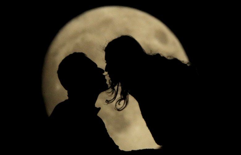 FILE – In this Nov. 10, 2019, file photo a couple kiss while watching the nearly full moon rise from a vantage point at the National WWI Museum and Memorial in Kansas City, Mo. Valentineâ€™s Day: a day to celebrate your partner or a day to celebrate yourself. And while it may not sound romantic, this time of year is also an opportunity to show your finances some love. (AP Photo/Charlie Riedel, File) NYBZ238 NYBZ238
