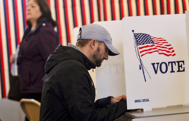 Christian Battaglia, of Chesterfield, N.H., sits down while filling out his ballot at the Chesterfield, N.H., Polling Station inside the Town Hall  during the New Hampshire presidential primary elections, Tuesday, Feb. 11, 2020. (Kristopher Radder/The Brattleboro Reformer via AP) VTBRA308 VTBRA308