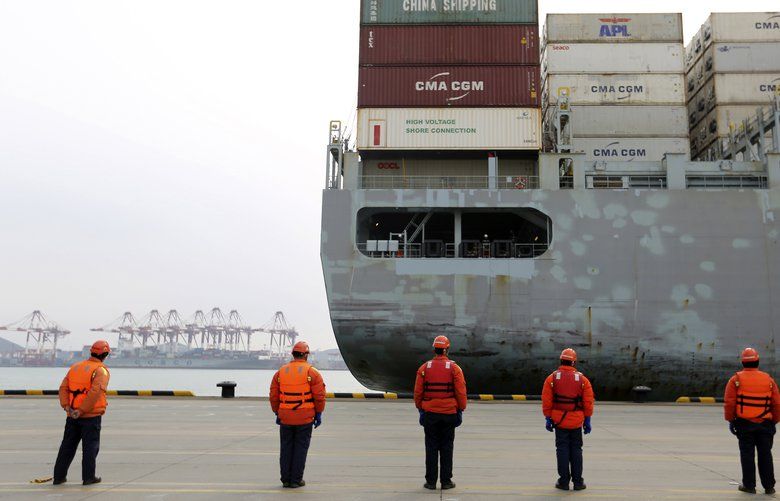 FILE – In this Feb. 4, 2020, file photo, workers watch a container ship arrive at a port in Qingdao in east China’s Shandong province. Factories across China are still closed to try to limit spread of the coronavirus, leaving business owners in limbo. (Chinatopix via AP, File) NYBZ370 NYBZ370