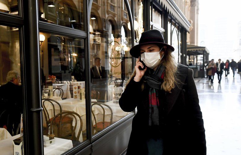 A woman wearing a sanitary mask talks on the phone as she walks in the Vittorio Emanuele Gallery shopping arcade, in downtown Milan, Italy, Monday, Feb. 24, 2020. At least 190 people in Italyâ€™s north have tested positive for the COVID-19 virus and four people have died, including an 84-year-old man who died overnight in Bergamo, the Lombardy regional government reported. (Claudio Furlan/Lapresse via AP) MIL806 MIL806