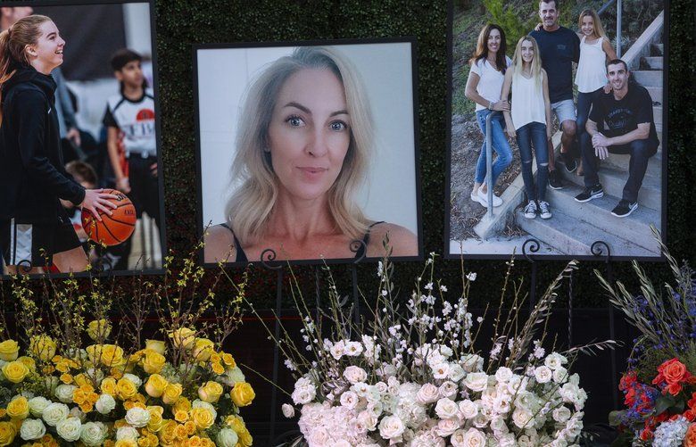 Flowers and photos honor members of the Altobelli family outside Angel Stadium, Monday, Feb. 10, 2020, in Anaheim, Calif. Coach John Altobelli, 56, far right, his wife, Keri, 43, second from left, and his daughter Alyssa, 13, left, died in a helicopter crash on Jan. 26 in Calabasas. (AP Photo/Damian Dovarganes) CADD108 CADD108