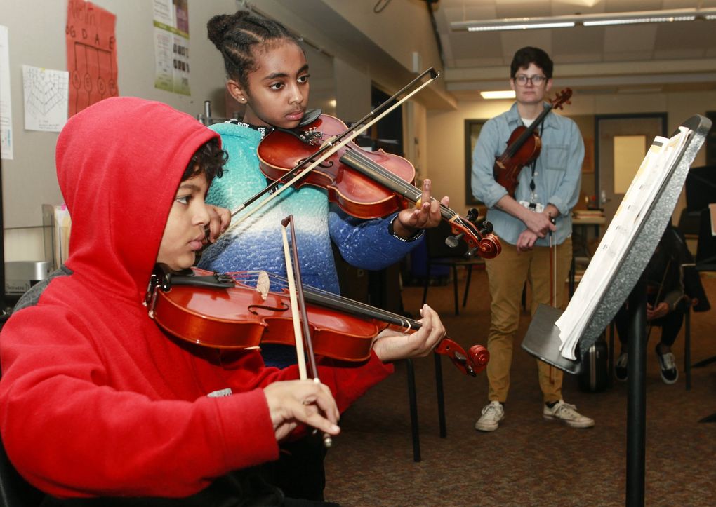 Soamory English from Roxhill Elementary School and Wegahta Giday from Highland Park Elementary School receive coaching from Kim Roy at Chief Sealth International High School. The schools are among those that partner with Seattle Youth Symphony Orchestra. (Mike Hipple)