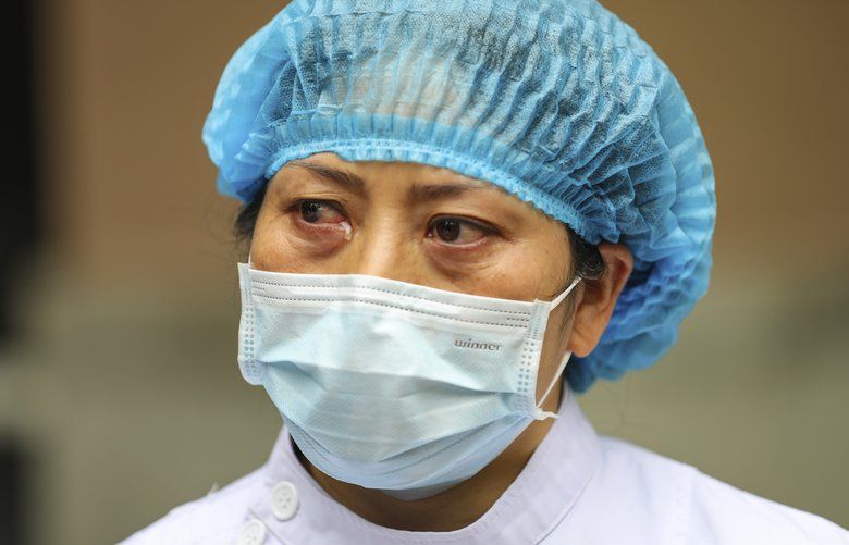 A nurse tears up as she talks about the situation in Jinyintan Hospital, designated for critical COVID-19 patients, in Wuhan in central China’s Hubei province Thursday, Feb. 13, 2020. China on Thursday reported 254 new deaths and a spike in virus cases of 15,152, after the hardest-hit province of Hubei applied a new classification system that broadens the scope of diagnoses for the outbreak, which has spread to more than 20 countries. (Chinatopix Via AP) XHG805 XHG805