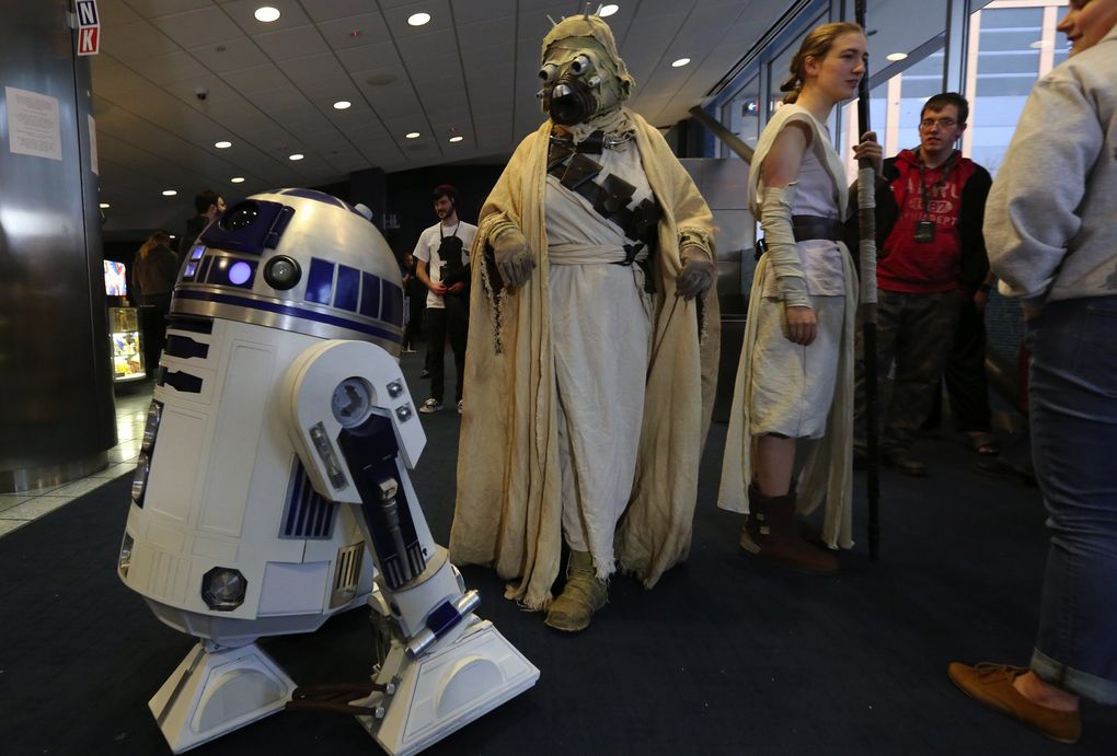A Tusken Raider checks out a full-scale model of R2-D2, built from scratch by Carol Semenchuk of Renton, in the lobby of the Seattle Cinerama Theatre in 2015. (Alan Berner / The Seattle Times)