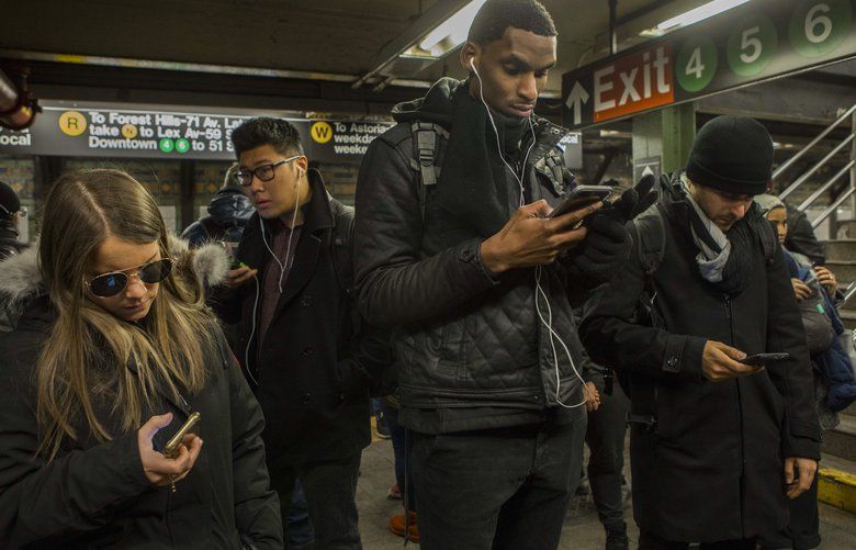 FILE — People use their phones on a subway platform in New York, Jan. 9, 2017. The Federal Communications Commission voted on Feb. 28, 2020, to fine T-Mobile, AT&T and two other cellphone carriers more than $200 million for selling customers’ location data to companies that allowed it to be misused by rogue law enforcement officers and others. (Hiroko Masuike/The New York Times) XNYT135 XNYT135