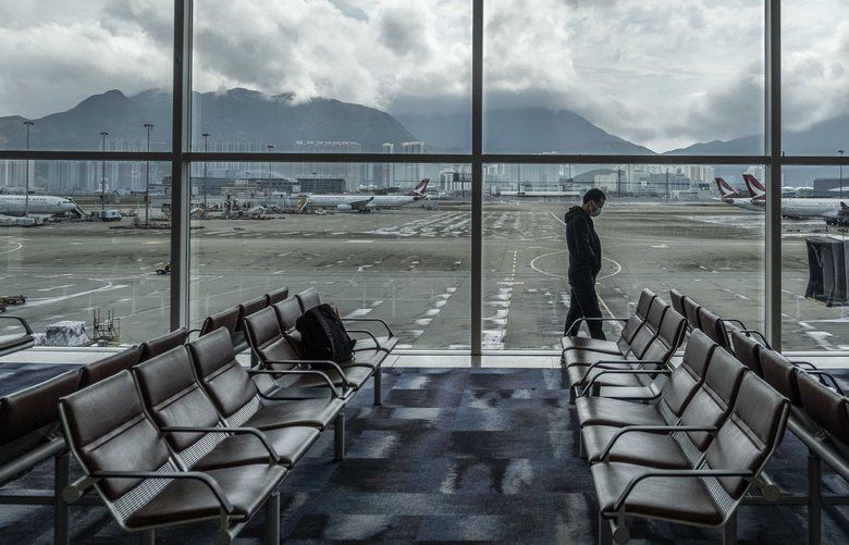 A man walks by windows at Hong Kong International Airport on Friday, Feb. 14, 2020. China on Friday reported 5,090 new coronavirus cases and 121 new deaths in the previous 24 hours. (Lam Yik Fei/The New York Times) XNYT5 XNYT5