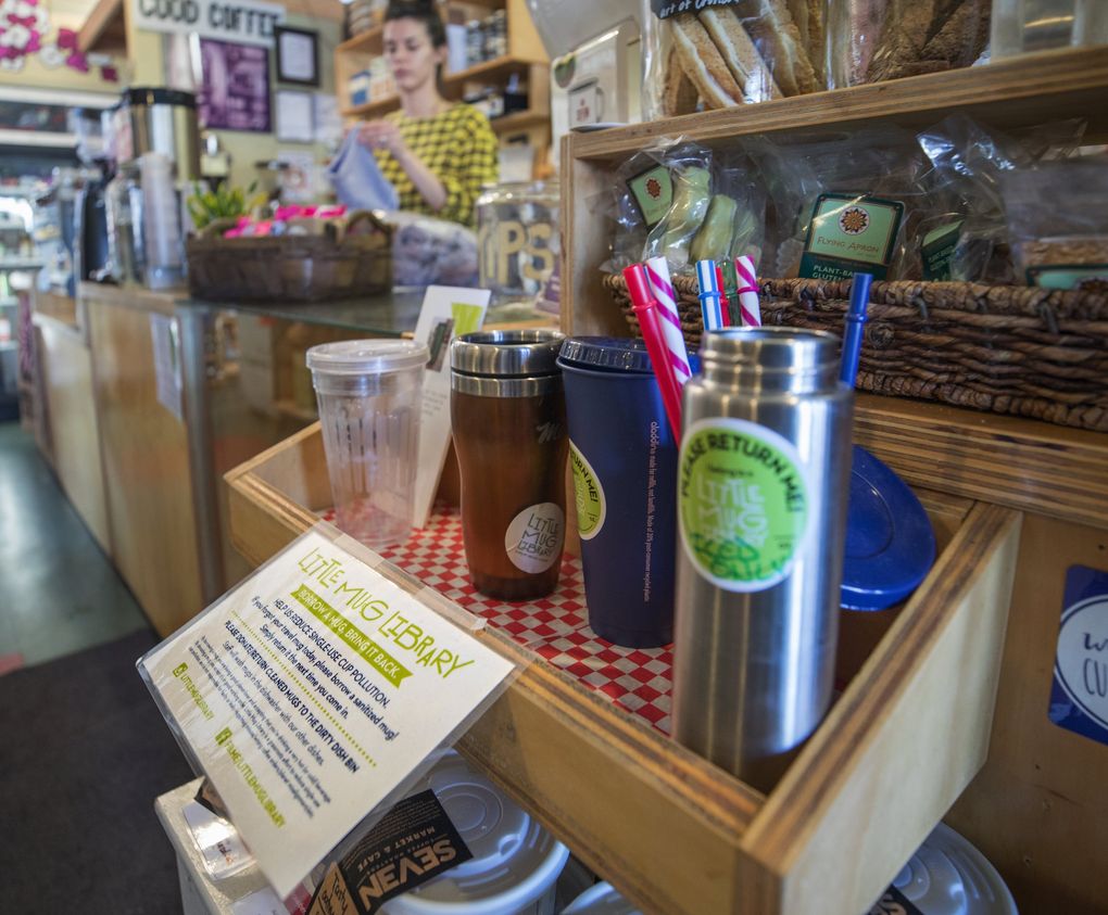 At the Little Mug Library at Seven Coffee Roasters Market and Cafe, patrons can barrow a cleaned, donated mug and skip the 10-cent charge for a paper cup. (Steve Ringman / The Seattle Times)