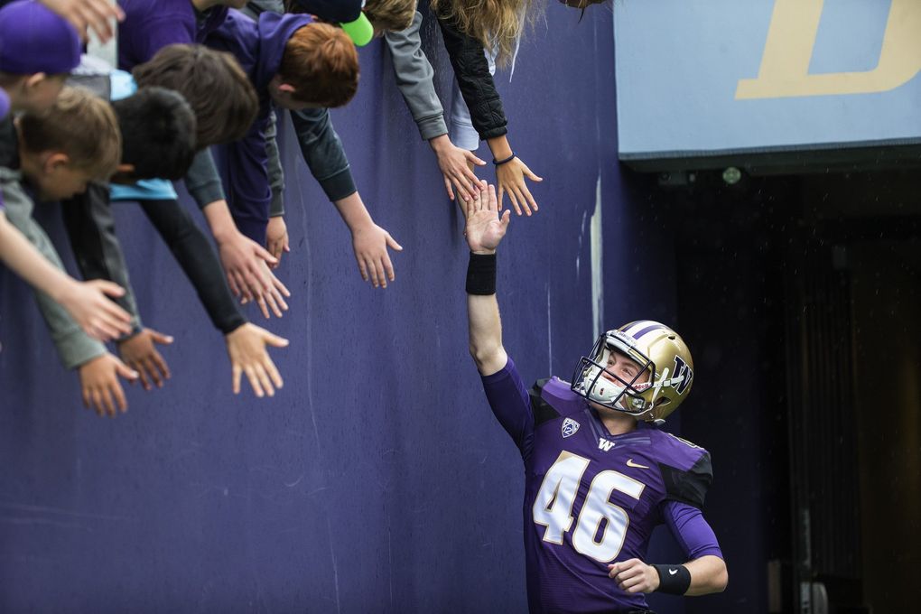Punter Race Porter is greeted by fans that line the wall at Husky Stadium before their spring game on April 22, 2017. (Dean Rutz / The Seattle Times)