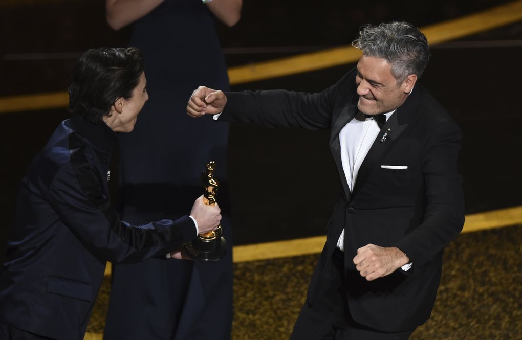 Timothee Chalamet, left, presents the award for best adapted screenplay to Taika Waititi for “Jojo Rabbit” at the Oscars on Sunday, Feb. 9, 2020, at the Dolby Theatre in Los Angeles. (AP Photo/Chris Pizzello) CADC227 CADC227 (Chris Pizzello / Chris Pizzello/Invision/AP)