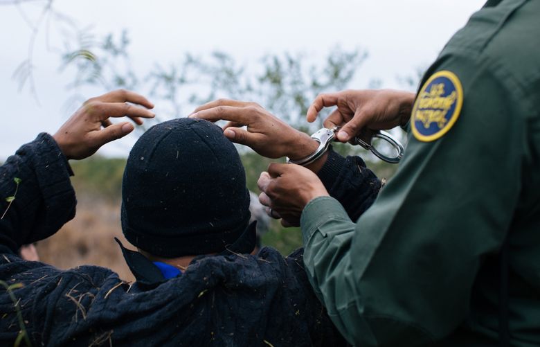 FILE — A U.S. Border Patrol agent apprehends a migrant hiding in a field near Sullivan City, Texas, Nov. 8, 2019. Immigrants who hope to challenge their deportation orders could be charged nearly $1,000 to go to court under a proposed new regulation. (Alyssa Schukar/The New York Times)