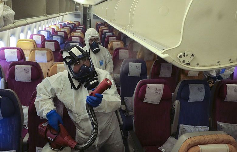Workers in protective suits spray inside an aircraft during a disinfection process in Thailand on Jan. 28. Photographer:… (Photographer: Patipat Janthong/Barcroft Media via Getty Images VIA Bloomberg) — use on Bloomberg story only —