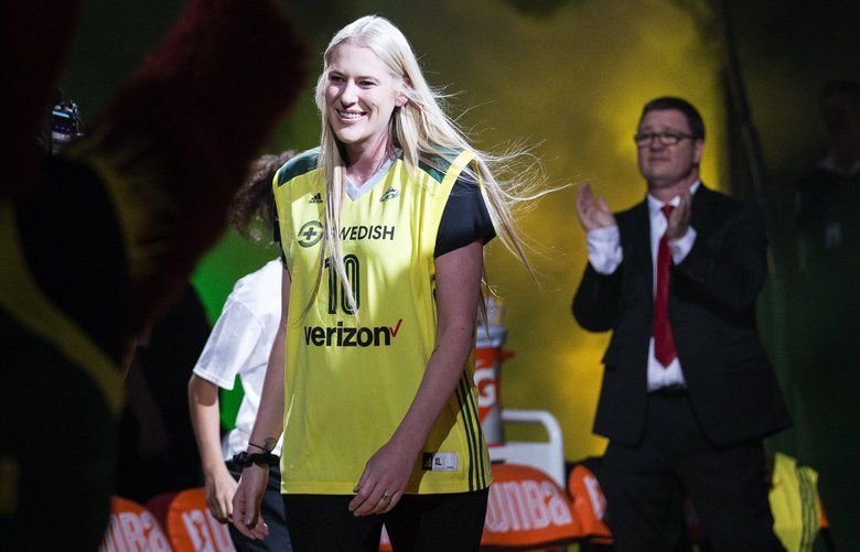 Former Storm player Lauren Jackson, wearing a Sue Bird jersey, smiles as she makes a surprise appearance during starting lineup introductions before the game between the Seattle Storm and Washington Mystics at KeyArena on Friday, July 15, 2016. Former Storm player Lauren Jackson, who was drafted in 2001 and spent her entire WNBA career in Seattle before injuries forced her to retire, was honored on Friday with the retirement of her jersey number, 15. Jackson helped the Storm win WNBA championships in 2004 and 2010, is a 7-time WNBA All-Star and three-time league MVP, among other accolades.
