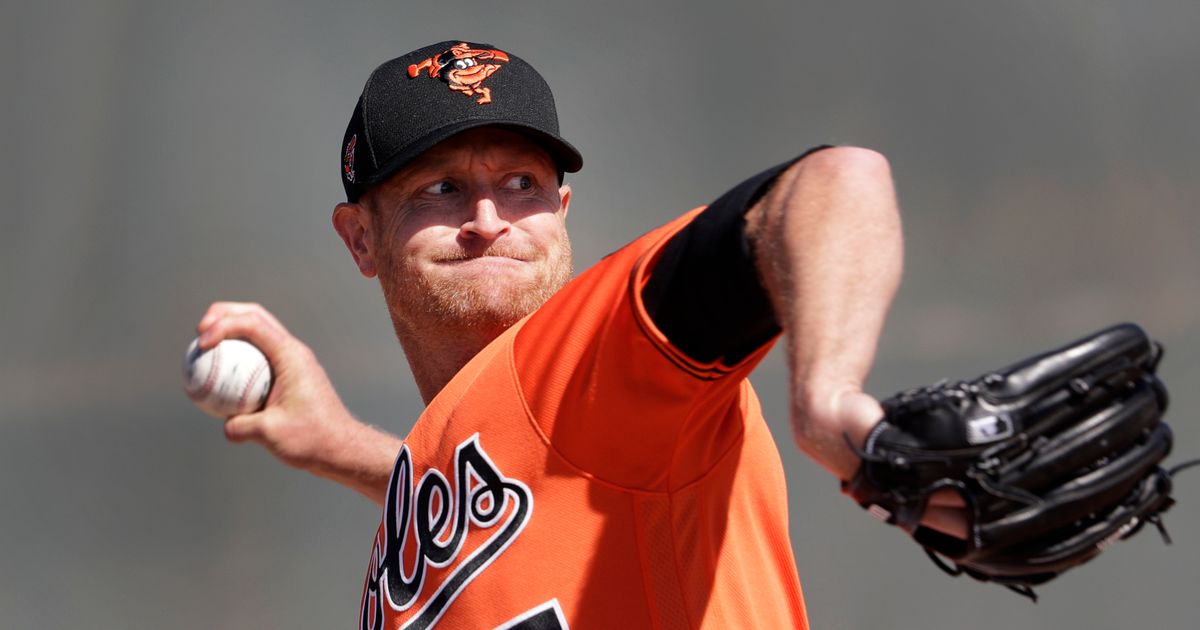 Pitcher Mychal Givens throws during the first day of workouts for