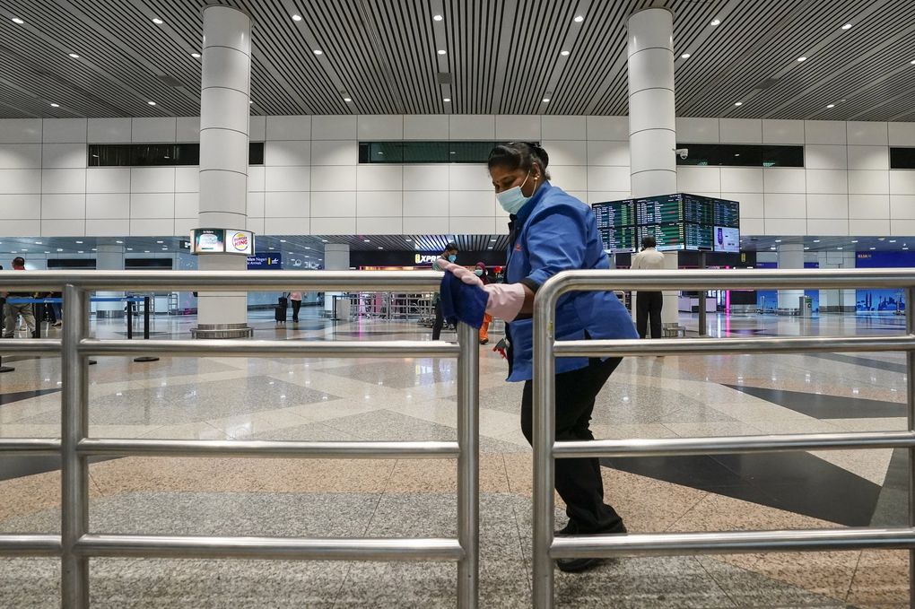 In this Feb. 4, 2020, photo, workers clean railings at the Kuala Lumpur International Airport in Sepang, Malaysia, as airlines and nations struggle to contain the spread of the new coronavirus. (Vincent Thian / The Associated Press)