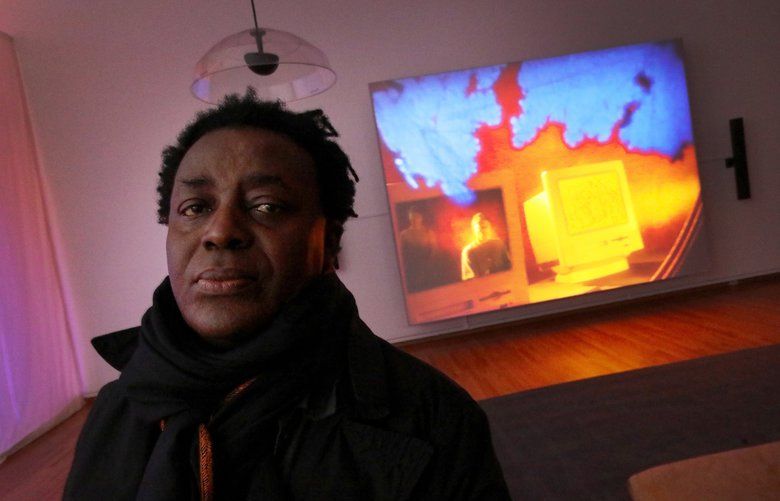 The London artist and filmmaker John Akomfrah is seen inside one of the three theaters comprising his show “Future History,” Tuesday, March 3, 2020, opening at Seattle Art Museum on Thursday. In the background is a 1995 45-minute film Akomfrah and Black Audio Film Collective made about Afrofuturism called “The Last Angel of History,” which runs continuously. 213204