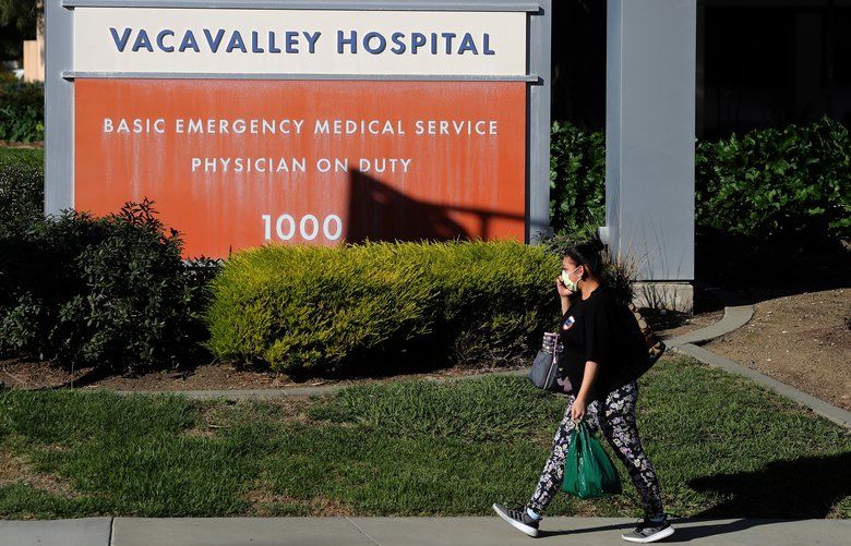 A pedestrian wears a surgical mask as she walks by the VacaValley Hospital on Feb. 27, 2020 in Vacaville, Calif. A Solano County resident now being treated for the coronavirus at UC Davis Medical Center was previously admitted to the Vacaville hospital but was not tested for the virus, officials said. (Justin Sullivan/Getty Images/TNS)  1588339 1588339