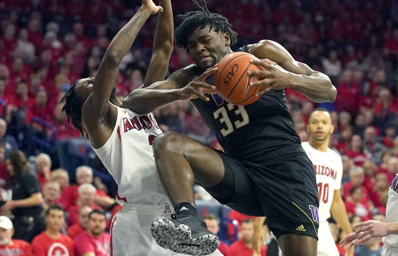 Washington forward Isaiah Stewart drives on Arizona guard Dylan Smith (3) during the first half of an NCAA college basketball game Saturday, March 7, 2020, in Tucson, Ariz. Smith broke his nose on the play. (AP Photo/Rick Scuteri) AZRS105 AZRS105