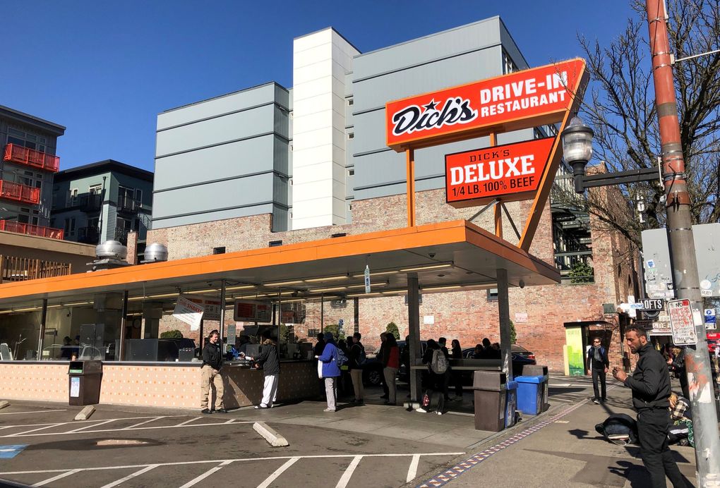 Lunchtime customers line up Monday at the Broadway location of Dick’s Drive-In, which is asking customers to pay with credit or debit cards instead of cash, in order to help prevent the spread of coronavirus. (Paul Roberts / The Seattle Times)