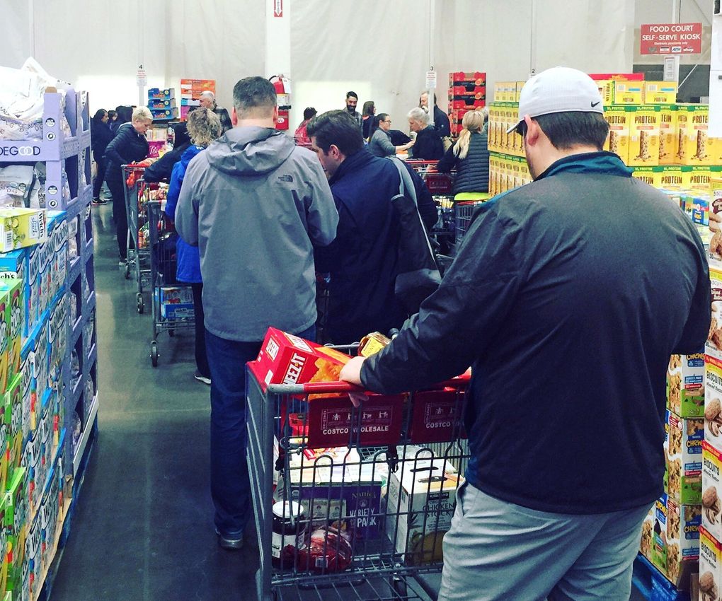 At 10:30 a.m. Thursday, the Costco on Fourth Avenue has been open for just a half an hour and the checkout lines were 8 and 9 people deep. Most customers are buying cleaning and paper products, and lots of Spam. (Nicole Brodeur / The Seattle Times)