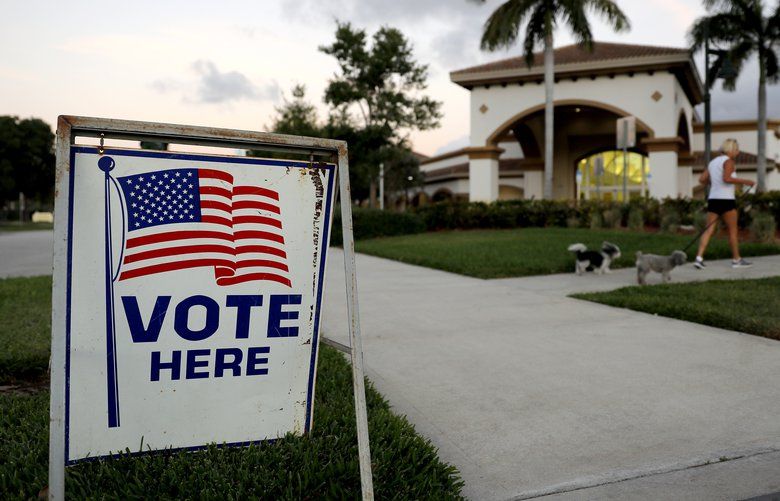 A sign is placed outside of a polling place at the Boca Raton Library during the Florida primary election, Tuesday, March 17, 2020, in Boca Raton, Fla.  As Florida officials try to contain the spread of the novel coronavirus, the state’s voters will head to the polls and cast ballots in the Democratic presidential primary.   (AP Photo/Julio Cortez) FLJC108 FLJC108