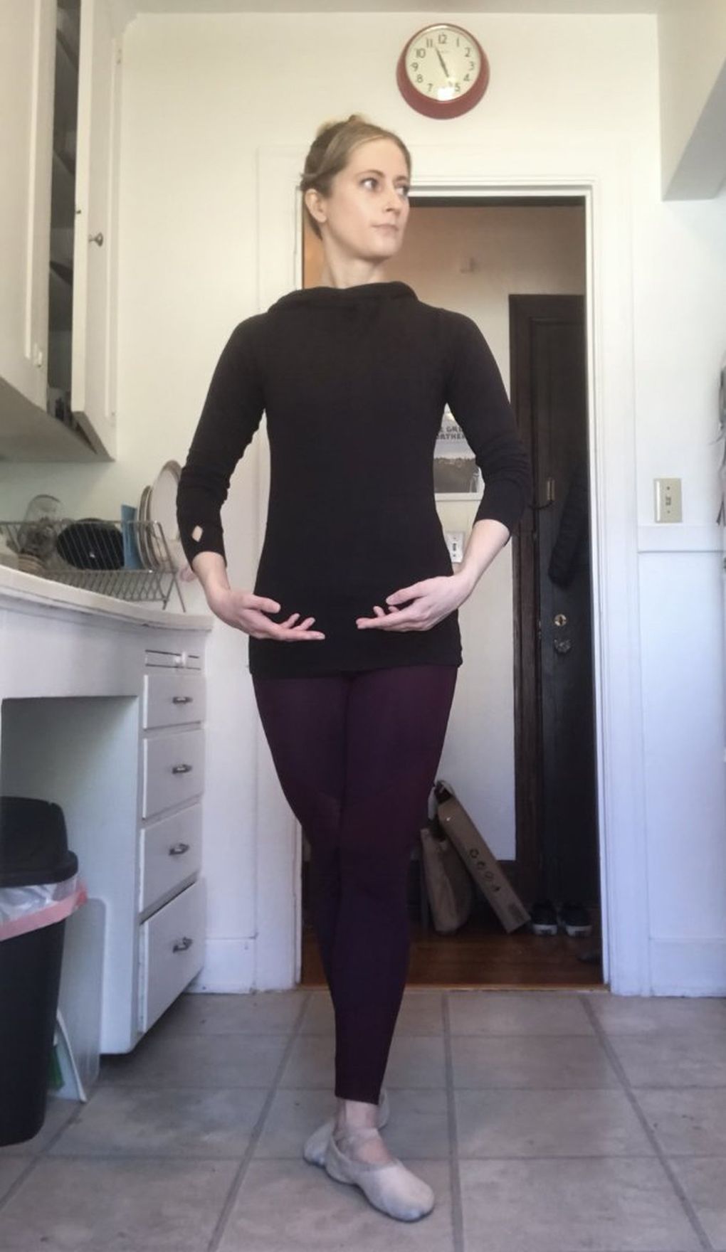 Megan Burbank does a basic barre routine, following the Ballerinas by Night video in her kitchen. (Megan Burbank / The Seattle Times)