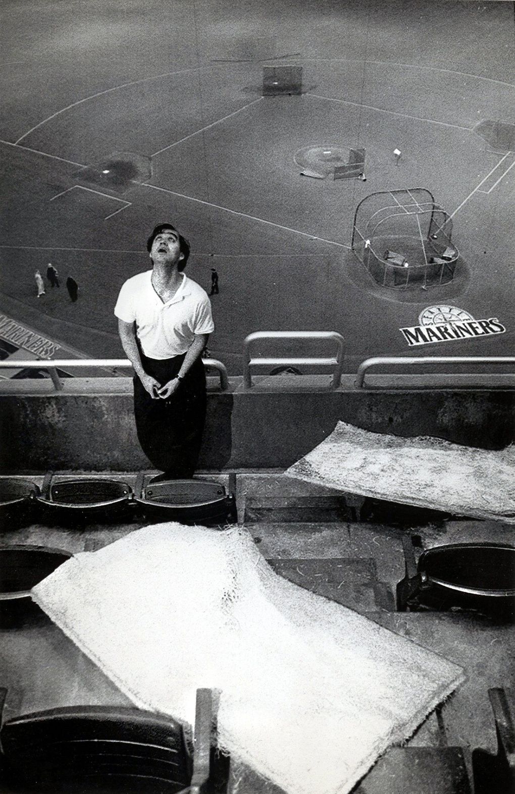 Tom Long, a Kingdome employee, examines the roof above the 300 level, where ceiling tiles fell onto some seats. July 20, 1994.(Rod Mar / The Seattle Times)