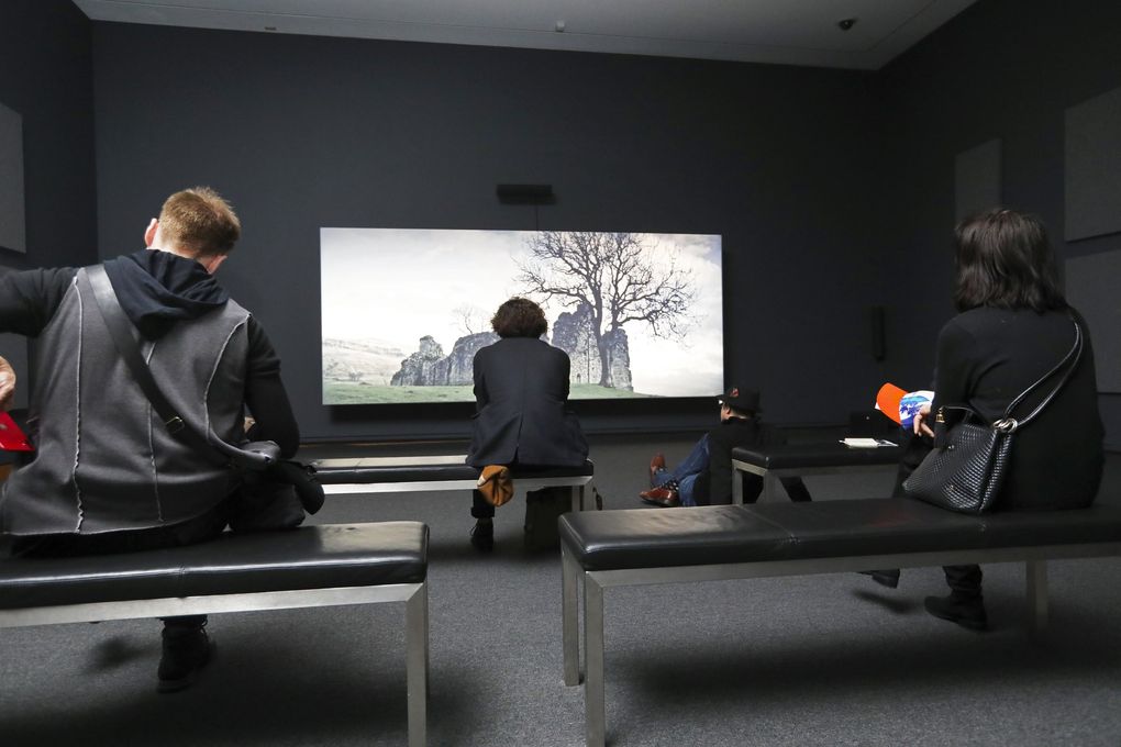 Viewers take in “Tropikos” (2016), a 36-minute film that’s part of Seattle Art Museum’s exhibit “John Akomfrah: Future History.” (Ken Lambert / The Seattle Times)