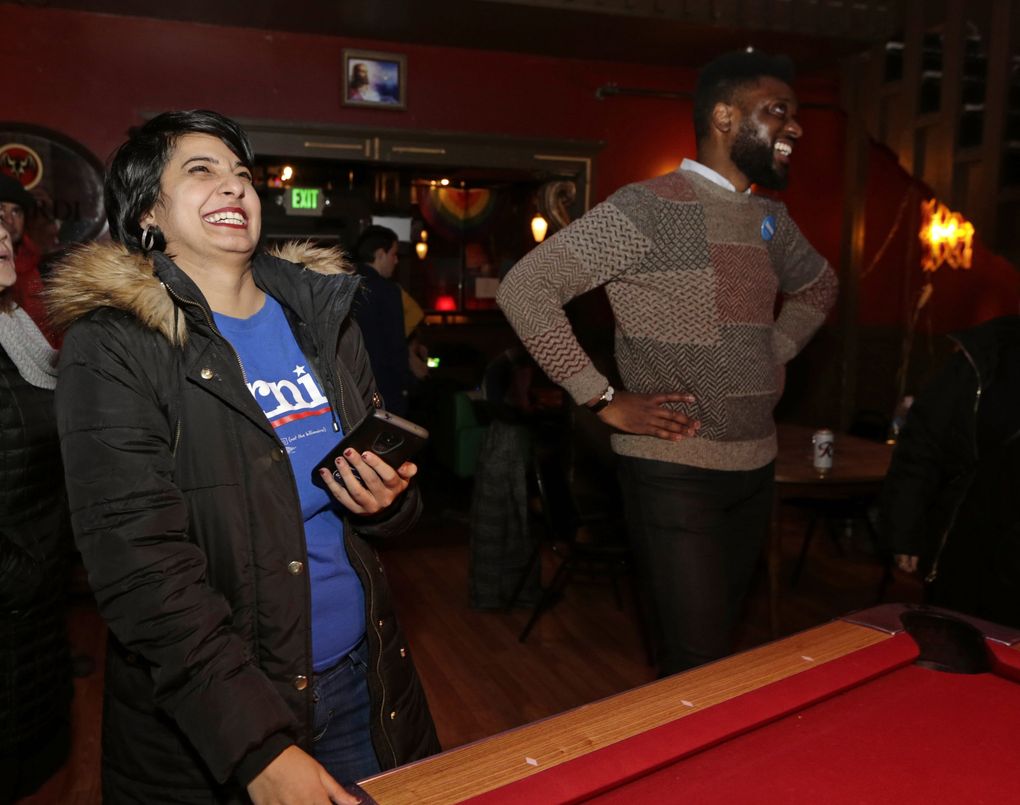 Supreet Kuar, left, and Shaun Scott react to the first votes from King County at an informal campaign party for Democratic presidential candidate Sen. Bernie Sanders, I-Vt., as the first results come in for the Washington state primary, Tuesday, March 10, 2020, in Seattle. (AP Photo/John Froschauer)