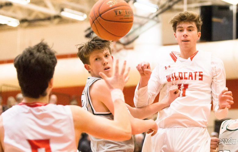 Mount Si’s Tyler Patterson (right) passes oer Skyline’s Hudson Vogel to Parker Wutherich as the Wildcats take on the Spartans at Mount Si High School on Friday, December 20. 208760 208760