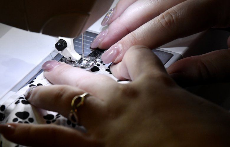 Alex Swize sews a face mask inside her living room in Abilene, Texas Saturday March 28, 2020.(Ronald W. Erdrich/The Abilene Reporter-News via AP) TXABI303 TXABI303