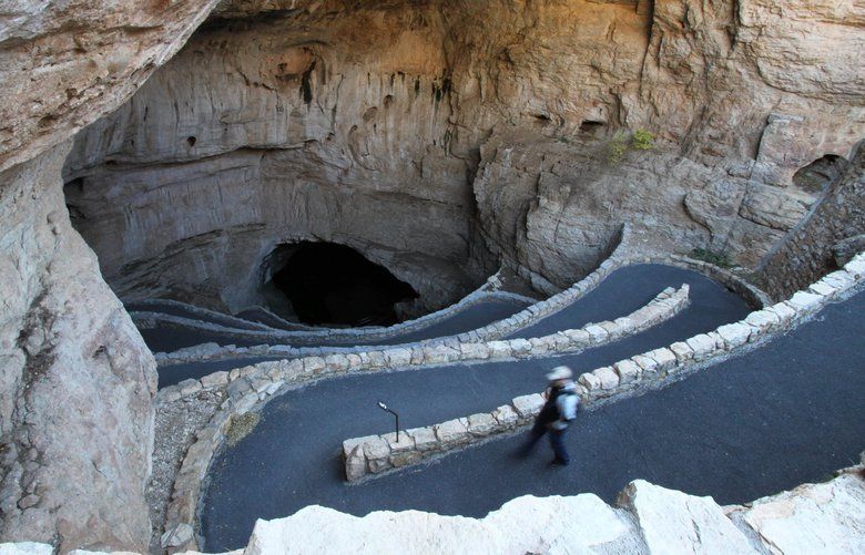 FILE – In this Dec. 18, 2010 file photo, a visitor walks down the natural entrance at Carlsbad Caverns National Park near Carlsbad, N.M. Environmentalists say U.S. land managers violated environmental laws and their own regulations when issuing dozens of leases to drill in one of the nation’s busiest oilfields.WildEarth Guardians filed a lawsuit Monday in U.S. District Court, claiming the oil boom in southeastern New Mexico is a threat to Carlsbad Caverns National Park and the surrounding area’s cave systems and desert slopes. (AP Photo/Susan Montoya Bryan, File) LA102