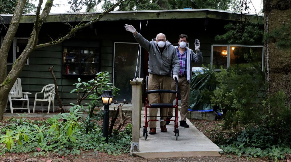 Earle Jones, World War II veteran and former Boeing engineer, emerges from his Issaquah home Saturday with son Jonathan to acknowledge well-wishers on his 99th birthday. (Alan Berner / The Seattle Times)