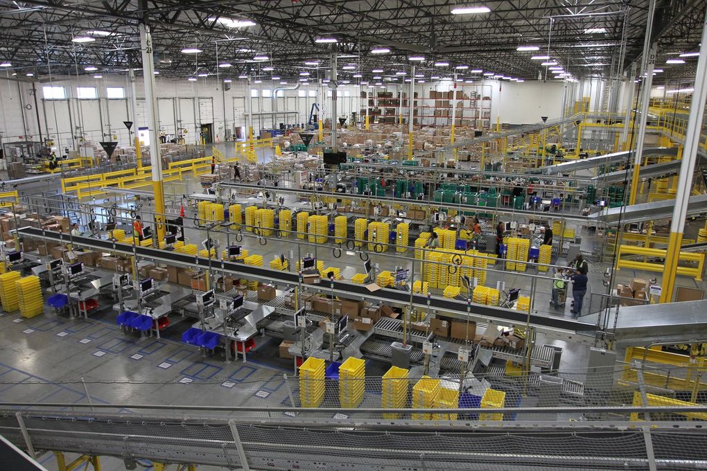 People work at an Amazon fulfillment center in San Bernardino, California. The area has become a hub for warehouses from Amazon and other companies, and climate-change activists at Amazon criticize the companies for creating high air-pollution levels.
(David McNew / The Associated Press)