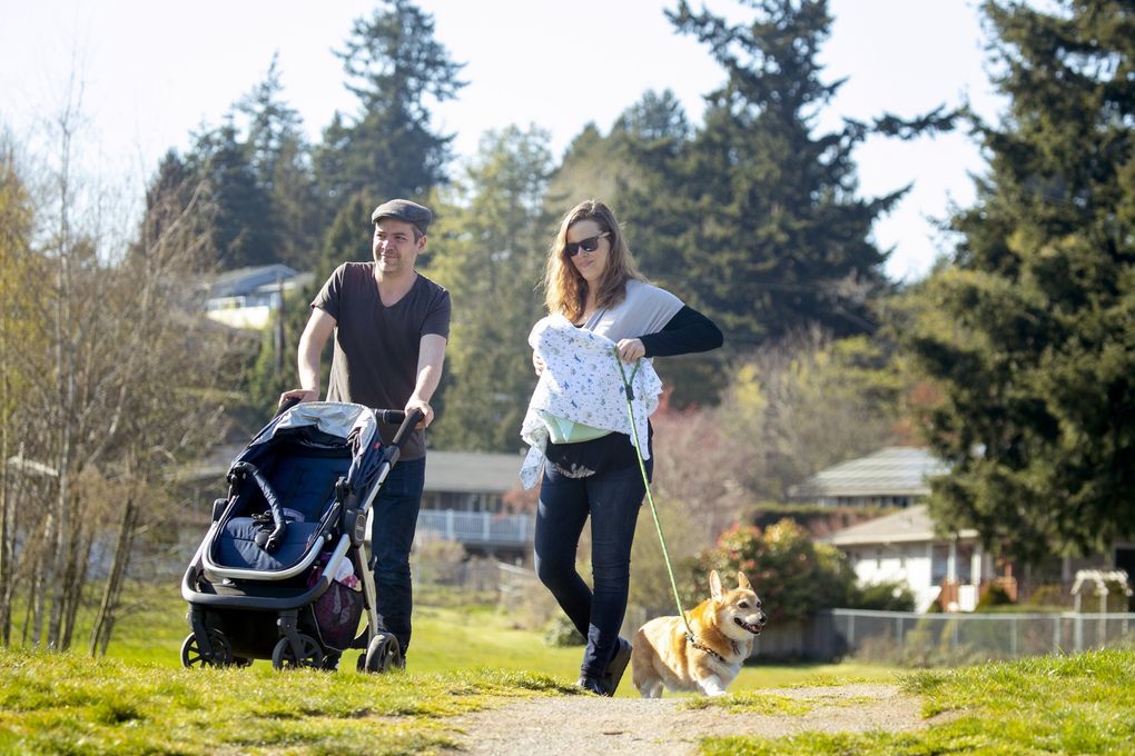 Steve Wilson and Emelia Udd, a certified nurse midwife, walk on a recent afternoon at Lake Ballinger. They have two daughters, Frances, 3, and newborn Wally. (Erika Schultz / The Seattle Times)