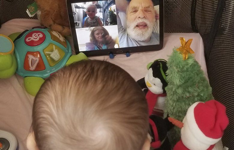 In this March 23, 2020, photo provided by Julie Bufkin, her 7-month-old boy, Calvin, interacts with his grandparents, Debbie and Allan Cameron, in Chandler, Ariz., on a FaceTime video call from his crib in Tempe, Ariz. The Camerons are among the grandparents all over the country going through a piercing distance from their loved ones for their own protection during the coronavirus crisis. (Julie Bufkin via AP) FX503 FX503