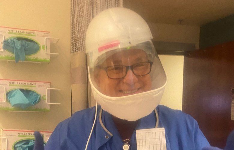 Anesthesiologist Dr. Brian Nyquist tests a Positive Air Pressure Respirator, which can maintain air pressure in the hood around his head to help protect against Covid-19 infection. During surgery the protective device would be worn with a mask over mouth and nose, as well as a gown and gloves.