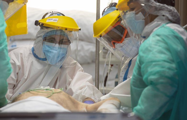 Healthcare workers assist a COVID-19 patient at one of the intensive care units (ICU) of the Ramon y Cajal hospital in Madrid, Spain, Spain, Friday, April 24, 2020. (AP Photo/Manu Fernandez) MF110 MF110