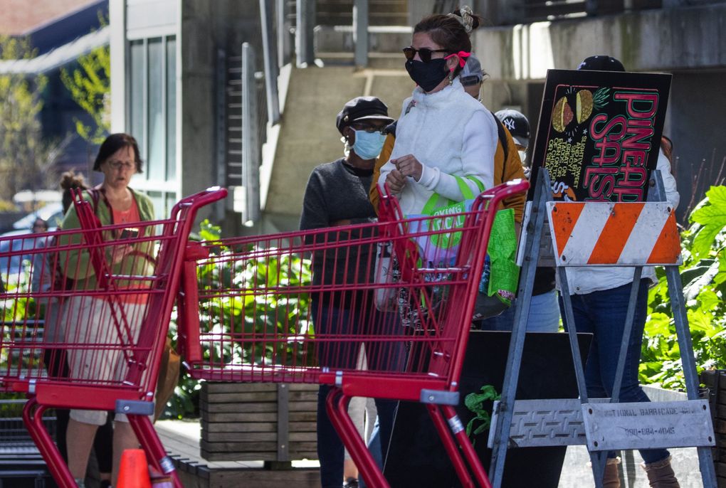 Customers are lined up outside the Trader Joe’s in Ballard on Monday morning. (Ellen M. Banner / The Seattle Times)