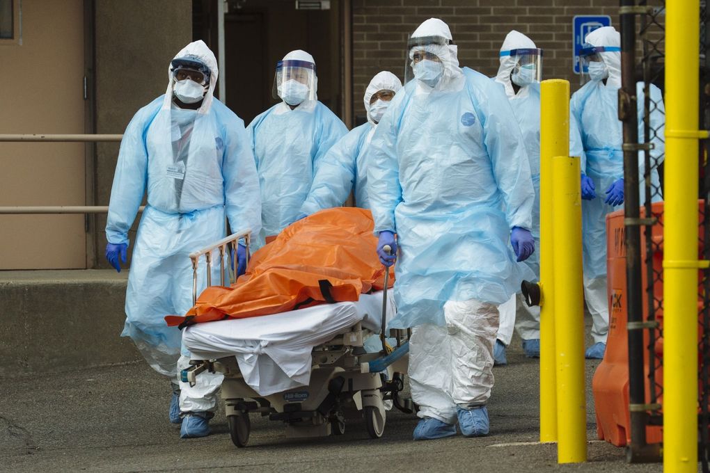 Medical workers move a body to an overflow morgue outside the Wyckoff Heights Medical Center in Brooklyn on Thursday. (Angus Mordant / Bloomberg)