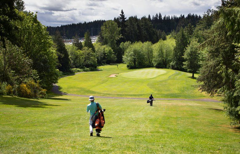 With a view of Interstate 5 in the distance, golfers Sam Cameron, left, and SanJuan Alvarado make their way down the 13th fairway at the Nile Shrine Golf Course
in Mountlake Terrace, Washington on Wednesday. 

Photo taken May 6, 2020. 213886