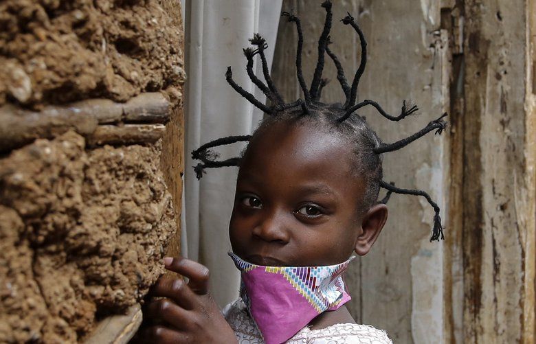 FILE – In this Sunday, May 3, 2020 file photo, Jane Mbone, 7, arrives home after having her hair styled in the shape of the new coronavirus at the Mama Brayo Beauty Salon in the Kibera slum, or informal settlement, of Nairobi, Kenya Sunday, May 3, 2020. The coronavirus has revived a hairstyle in East Africa, one with braided spikes that echo the virus’ distinctive shape, with the growing popularity in part due to economic hardships linked to virus restrictions. (AP Photo/Brian Inganga, File) NAI105 NAI105