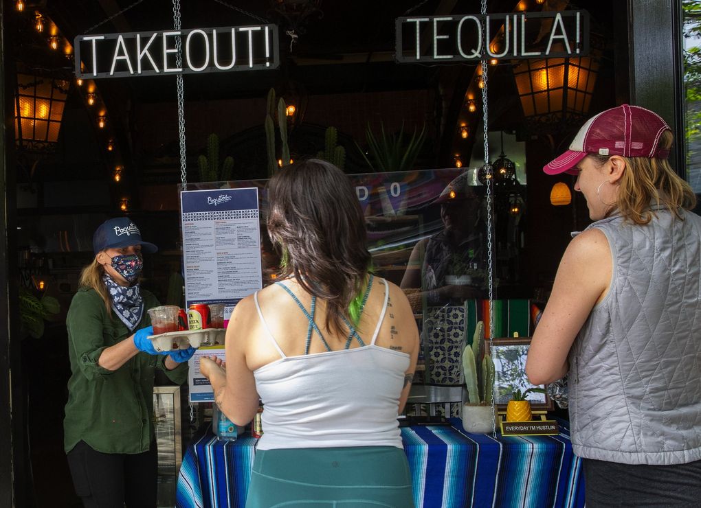 General Manager Liz Elkins hands drinks to customers at Poquitos in Capitol Hill. Gov. Jay Inslee has released new guidelines for restaurants planning to reopen once the stay-home order is lifted. (Ellen M. Banner / The Seattle Times)