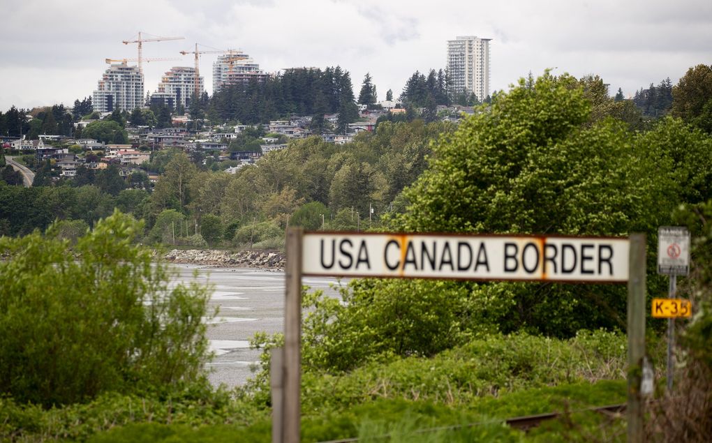 This sign at Peace Arch Park marks the actual border between the United States and Canada. White Rock B.C. is seen in the distance. (Mike Siegel / The Seattle Times)