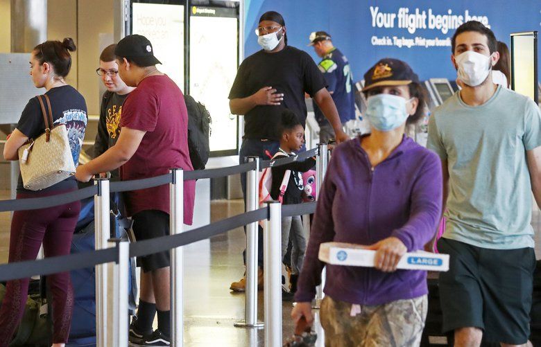 Passengers are seen at Seattle-Tacoma International Airport, Sunday, May 10, 2020 in Seattle during the coronavirus outbreak. The airport is last among major West Coast airports to implement mandatory mask wearing, a formal policy for Sea-Tac airport is still more than a week away and details are yet to be worked out. 213936