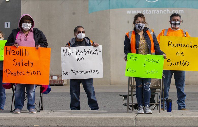 Workers from Columbia Reach Pack hold signs while on strike in front of the business, Thursday, May 14, 2020 in Yakima, Wash. (Evan Abell/Yakima Herald-Republic via AP) WAYAK102 WAYAK102