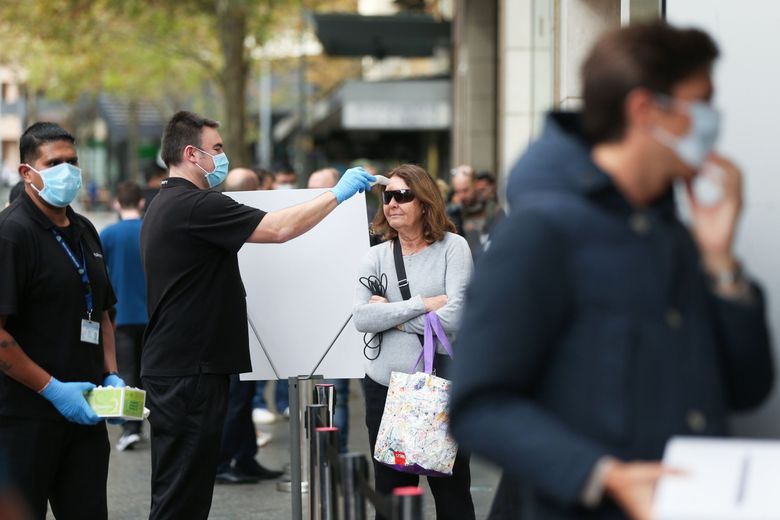 A female customer carries an Apple shopping bag at an Apple retail