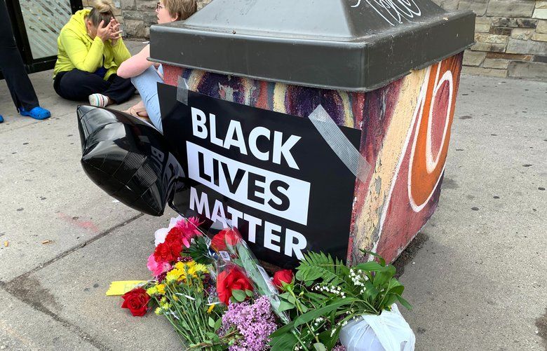 People gather around a makeshift memorial Tuesday, May 26, 2020, in Minneapolis, near where an black man was taken into police custody the day before who later died. The FBI and Minnesota agents are investigating the death of a black man in Minneapolis police custody after video from a bystander showed a white officer kneeling on his neck during his arrest as he pleaded that he couldn’t breathe.  (AP Photo/Jeff Baenen) RPJB101 RPJB101